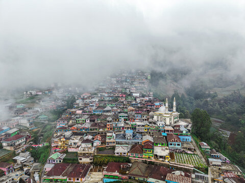 Aerial view of Nepal Van Java, a colorful village on the slopes of Mount Sumbing with a mosque, terraced fields, and mountain mist in Magelang, Central Java, Indonesia.