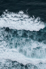 Obraz premium Natural background of blue ocean waves with white sea foam and turquoise water, abstract natural seascape poster