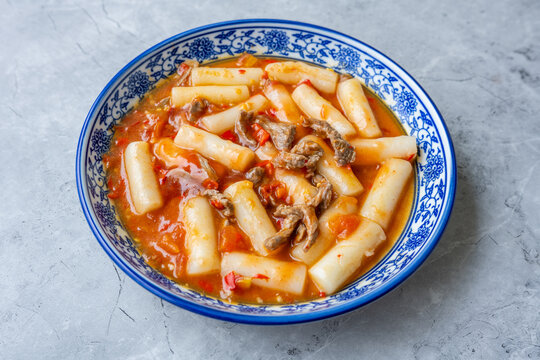 A plate of stir-fried rice cakes with beef and tomato