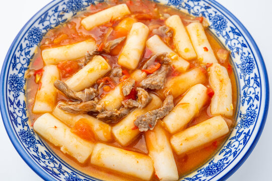 A plate of stir-fried rice cakes with beef and tomato