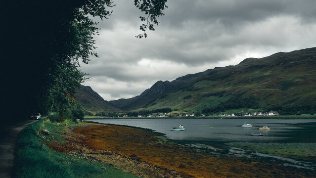 car driving by lake in the mountains of Scotland