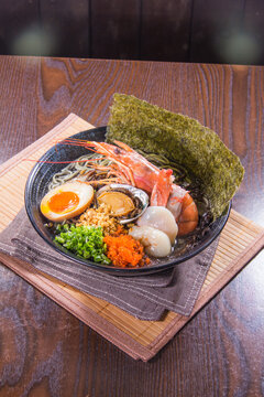 Delicious bowl of ramen served with seafood, eggs, and green onions