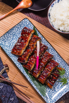 Delicious grilled eel served with rice and garnishes on a plate