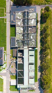 Aerial view of the Depuratore di Peschiera Borromeo wastewater treatment plant with aeration tanks, solar panels, and industrial infrastructure in Peschiera Borromeo, Lombardia, Italy.