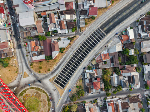 Aerial view of Jembatan Kereta Api Joglo with its distinctive railway structure crossing over urban roads and rooftops in Surakarta, Jawa Tengah, Indonesia.