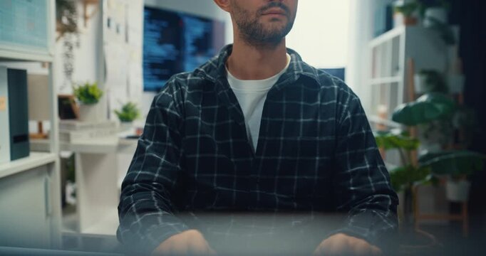 Close up young Caucasian male programmer writes code using multiple screens in home office workspace. AI development, cybersecurity, network database system, software engineering, remote tech startup.