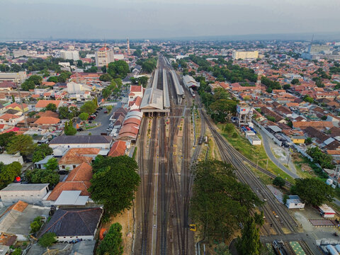 Aerial view of Stasiun Kejaksan with its railway tracks and platforms surrounded by the urban landscape of Cirebon, West Java, Indonesia.