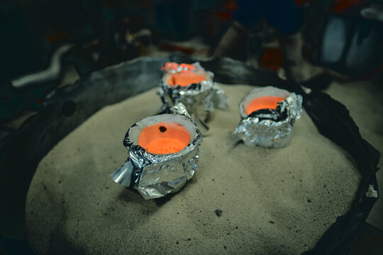 A Molten pot collection scorching molten hot lava refining furnace, precious metal smelting and industrial metallurgy. Precious metals being smelted and melted fashioned into artefacts.