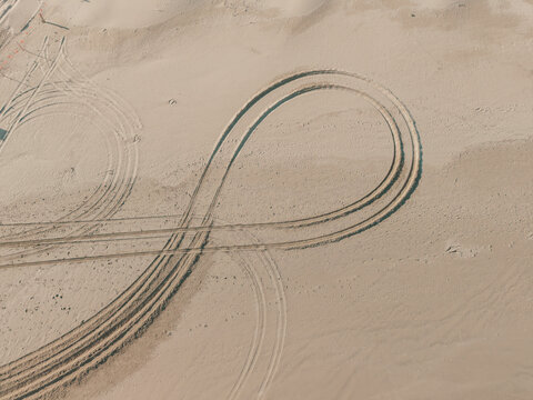 Aerial view of tire tracks forming patterns on the sand dunes at Birubi Point in Anna Bay, New South Wales, Australia.