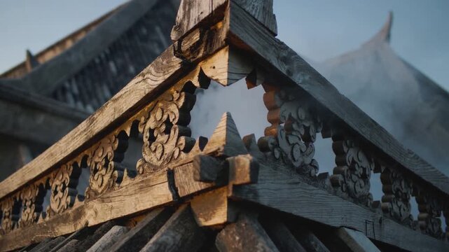 Pulling back camera revealing carved wooden roof apex at temple, showing fretwork, beams, mist