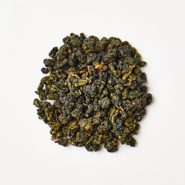 Dried green oolong tea leaves on white background