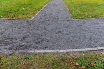 Obraz premium Grey gravel of a garden path next to the lawn, no person