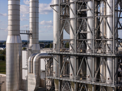 Aerial view of the industrial facility featuring tall steel towers, complex piping systems, and metal structural frameworks in Gdansk, Poland.