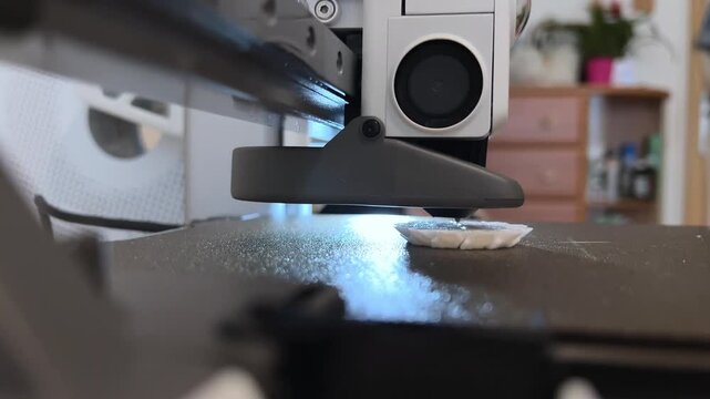 Close-up video of a mini 3D printer operating, printing at home