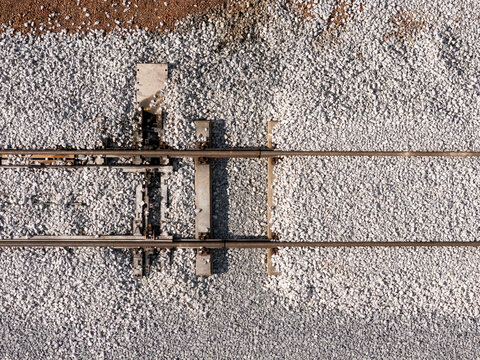 Aerial view of railway tracks with gravel ballast and a track switching mechanism in Gdansk, Poland.