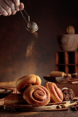 Obraz premium Freshly baked doughnuts are sprinkled with ground cinnamon.