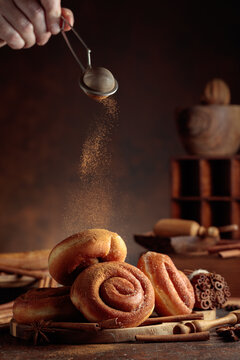 Freshly baked doughnuts are sprinkled with ground cinnamon.