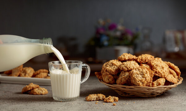 Oatmeal cookies and milk on a kitchen table.