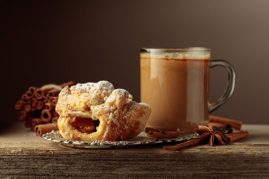 Viennese strudel and coffee latte on an old wooden table.