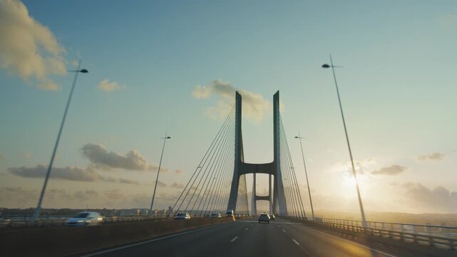 Driving on Vasco da Gama cable stayed bridge at sunset view from car camera, Lisbon, Portugal. Longest bridge in Europe over Tagus river. 