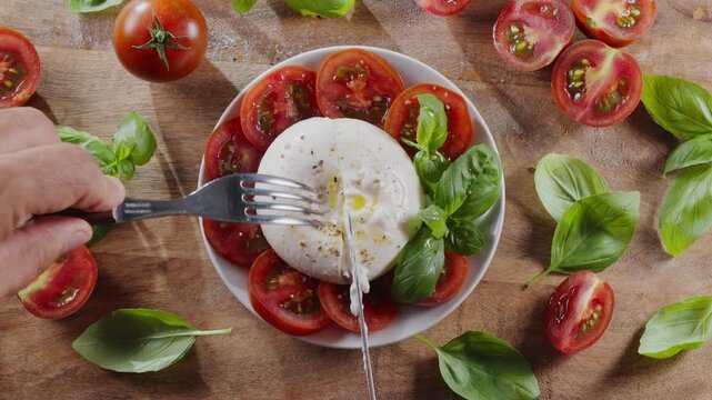 Flat lay of burrata cheese surrounded by cherry tomatoes and basil on wooden table. Mediterranean traditional food.
