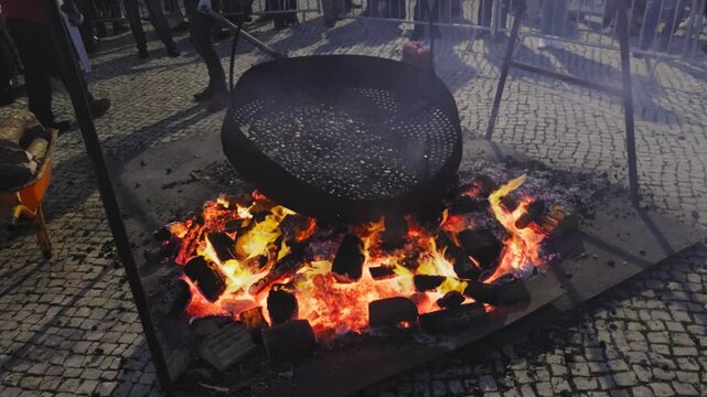  Roasting chestnuts on an open fire in the streets of Portugal, popular autumn street food in Europe and Asia.