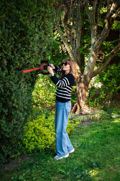 Mid-aged woman and removing old stems and leaves in a back yard