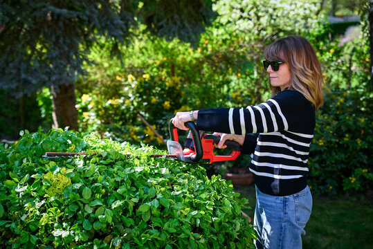 Mid-aged woman gardening in a back yard