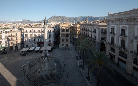 Aerial perspective of the 18th-century Column of the Immaculate Conception in Palermo, showing its elaborate stone staircase base, surrounding wrought-iron fence, and classical statue.