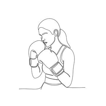Female boxer wearing gloves in fighting stance during training