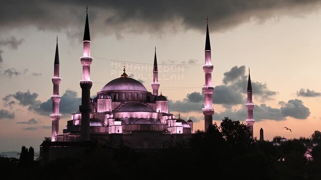 View of the illuminated New Mosque at night with its domes and minarets reflecting over the Golden Horn in Istanbul, Istanbul, Turkiye.