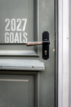 2027 GOALS Written on a Vintage Green Door with Wooden Handle