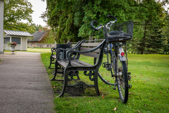 Bicycle with Front Basket Parked Beside Benches on a Park Path