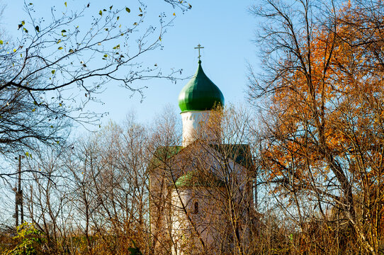 Veliky Novgorod Russia, church of St John on the Vitka river, autumn trees with orange leaves framing the building against a blue sky