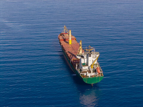 Aerial view of a large cargo ship sailing on the deep blue Mediterranean Sea in Lemesos, Lemesos, Cyprus.