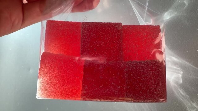 Marmalade Cubes in a Bag Held Up to Bright Sunlight