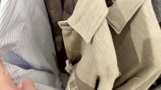 Hand Browsing Formal Jackets on a Clothing Store Rack