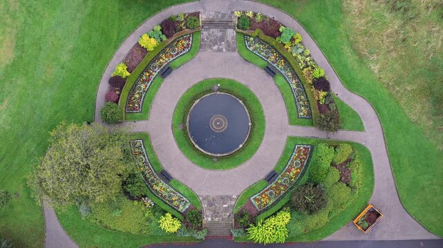 Aerial Rise-Up Video of Alexandra Park Circular Ornamental Fountain and Flowerbeds in Oldham, Greater Manchester. 