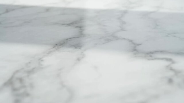 Pale white marble surface drifts gently across a veined stone texture. Interior design presentations, home renovation advertising, and countertop and flooring promotion.