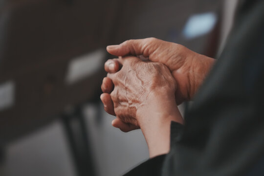 Human hands holding and interlocking fingers praying
