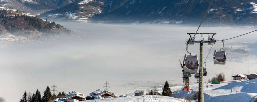 Modern spacious big cabin ski lift Kitzsteinhorn gondola snowcapped forest tree mountains snow landscape luxury winter alpine resort. Winter leisure recreation travel