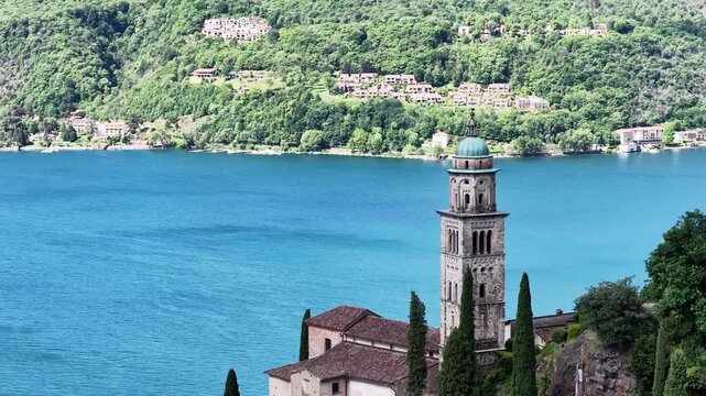 Santa Maria del Sasso bell tower rises above Lake Lugano in Morcote, Ticino, Switzerland