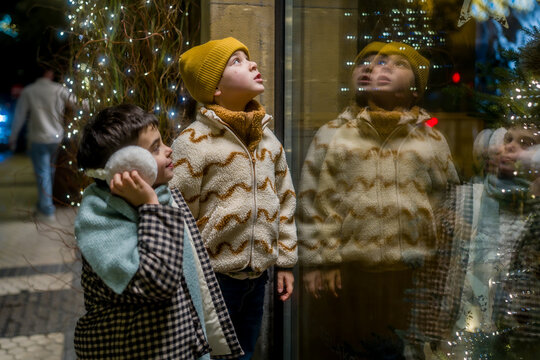 Children looking at festive christmas shop window display