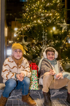 Children sitting outdoors celebrating christmas holiday season