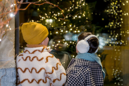 Children looking at illuminated shop window during christmas holiday
