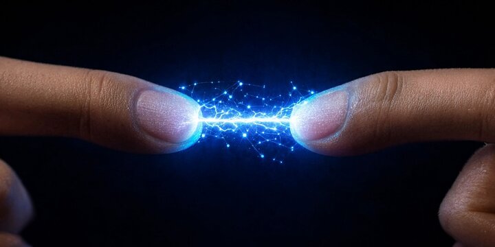 Conceptual image of two human fingers touching creating a bright electrical spark of connection and digital energy