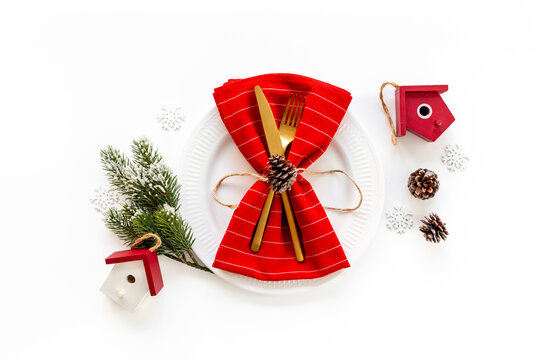 Empty plate with fir tree branch and red colored decoration. Table setting top view