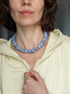 Portrait of brown hair woman wearing quartz stone jewelry necklace - warm neutral aesthetic with natural beauty style