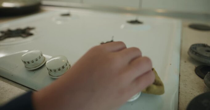 Close-up children's hands wash gas stove kitchen. 4K 10-bit
