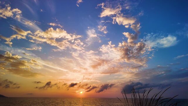 Panoramic view of the golden sunset over the sea horizon with beautiful, picturesque clouds.
